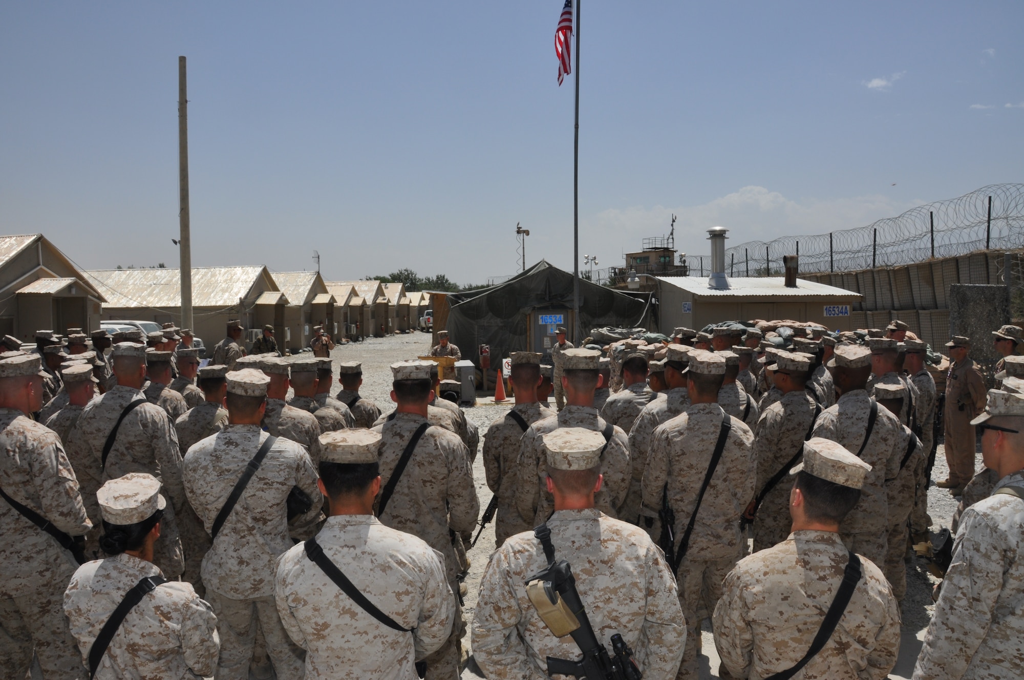 Members of the Marine Tactical Electronic Warfare Squadron-2 pause to honor their unit's history during Camp McCool's closing ceremony at Bagram Airfield, Afghanistan, Aug. 8, 2012. The ceremony reminded Camp McCool's final residents of its brief-but-important nine-year history. The camp was the site of an insurgent attack on Bagram in 2009. The camp was named in honor of U.S. Navy Commander William C. McCool, fellow EA-6B Prowler pilot, and pilot of the Space Shuttle Columbia's ill-fated STS-107, which broke up during its return to Earth in February 2003. (U.S. Air Force photo/TSgt Shawn McCowan)