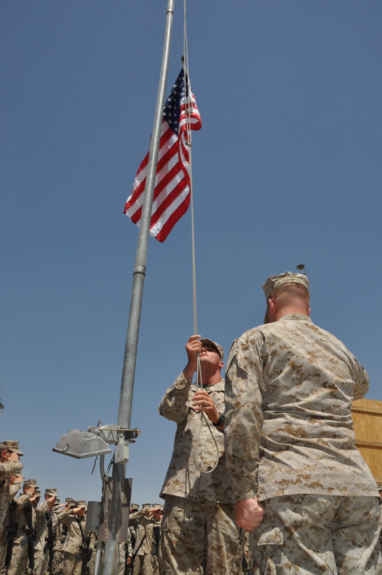 Members of the Marine Tactical Electronic Warfare Squadron-2 lower their unit's American Flag for the final time during "Camp McCool's" closing ceremony at Bagram Airfield, Afghanistan, Aug. 8, 2012. The ceremony reminded Camp McCool's final residents of its brief-but-important nine-year history. The camp was the site of an insurgent attack on Bagram in 2009. The camp was named in honor of U.S. Navy Commander William C. McCool, fellow EA-6B Prowler pilot, and pilot of the Space Shuttle Columbia's ill-fated STS-107, which broke up during its return to Earth in February 2003. (U.S. Air Force photo/TSgt Shawn McCowan)