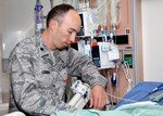 Air Force Lt. Col. (Dr.) Jeremy Cannon checks on a critically injured patient at the San Antonio Military Medical Center intensive care unit, Ft. Sam Houston, Texas.  Dr. Cannon, chief of trauma and acute care surgery at SAMMC and assigned to the 59th Medical Wing, is the guest editor of the August edition of the "Surgical Clinics of North America." (U.S. Army photo/Dwayne R. Snader)