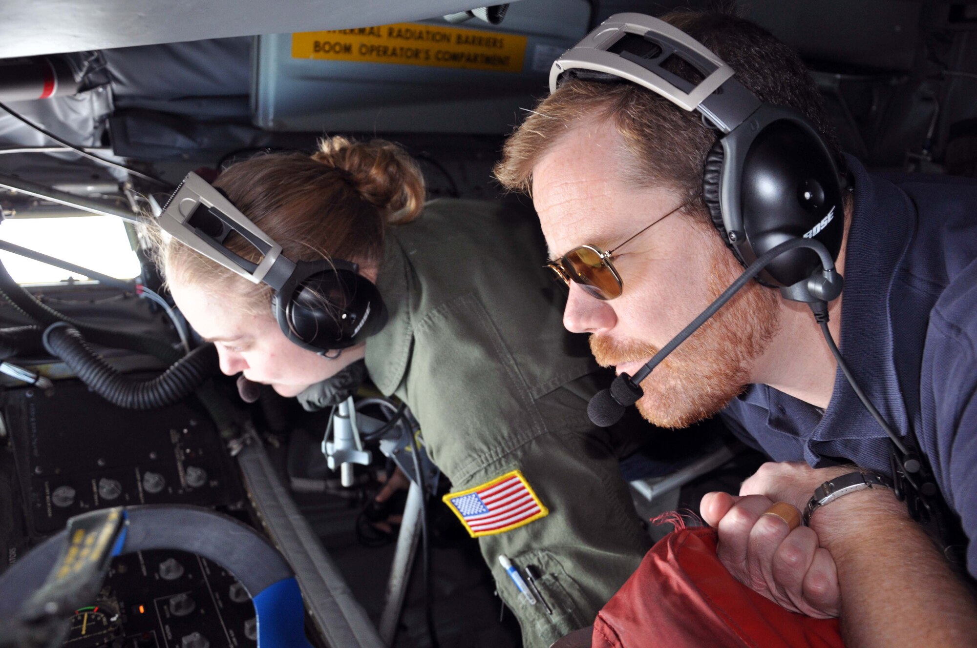 Eric Schmutz, staff member with the office of Congresswoman Lynn Jenkins, observes the air refueling of a B-1B Lancer while riding in the boom pod of a KC-135 Stratotanker next to Senior Airman Sierra Dopfel, a Reservist boom operator assigned to the 18th Air Refueling Squadron, 931st Air Refueling Group, McConnell Air Force Base, Kan, August 23, 2012.   Seven congressional staffers participated in an orientation flight.  (U.S. Air Force photo by 1st Lt. Zach Anderson)