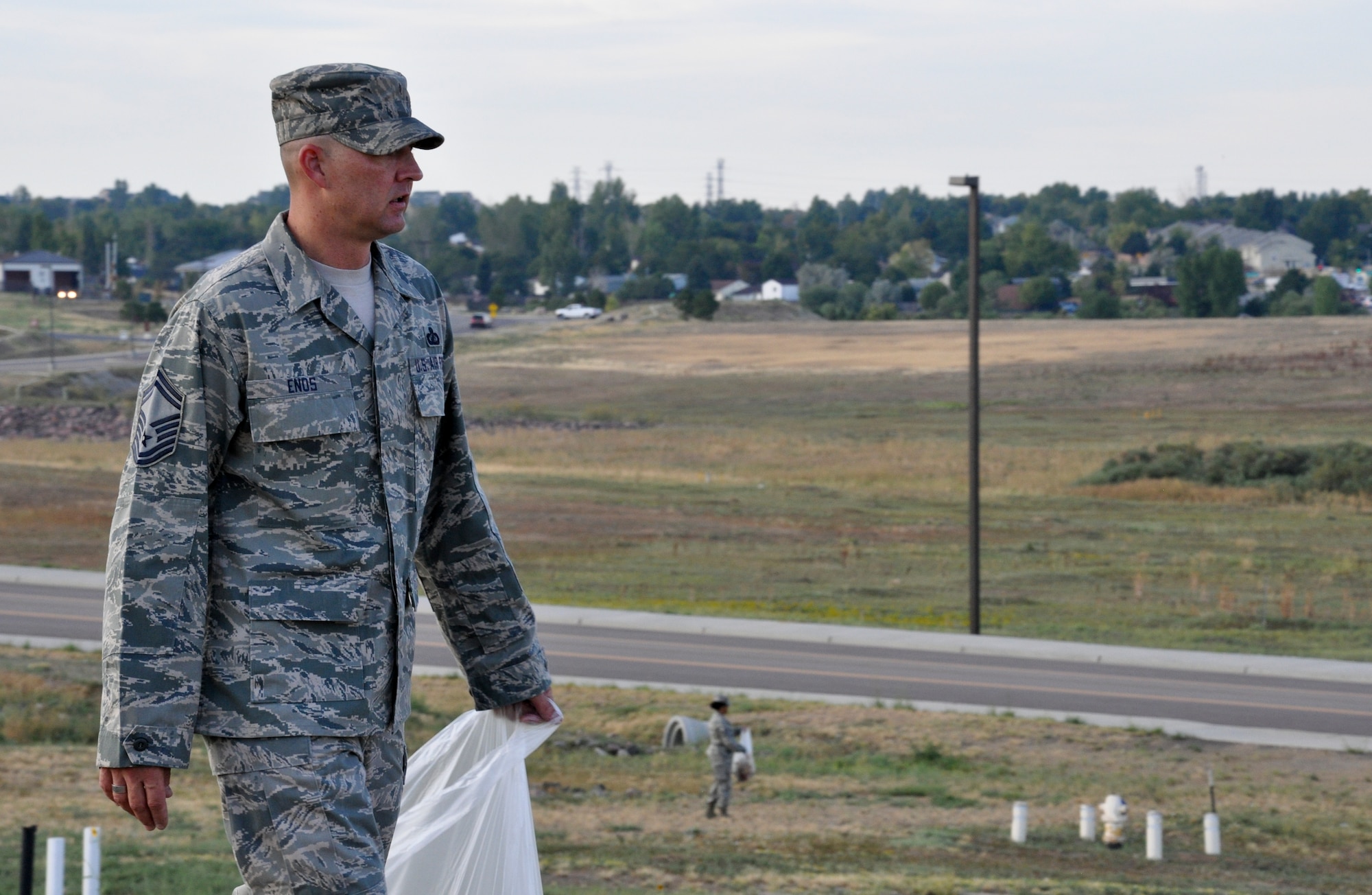 BUCKLEY AIR FORCE BASE, Colo. – Senior Master Sgt. Shane Enos, 460th Comptroller Squadron and Space Wing Staff superintendent, oversees the clean up behind the wing staff building during a base beautification event Aug. 23, 2012.  “Base cleanup is essential,” he said. “As Air Force professionals we adhere to the highest standards, and professional appearance is one of them.”  (U.S. Air Force photo by Staff Sgt. Nicholas Rau)