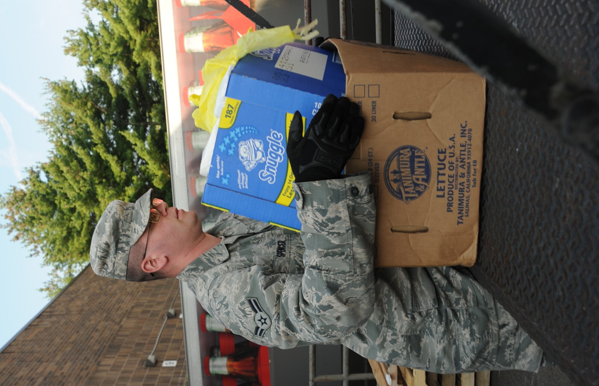 Airman 1st Class John Spencer, 87th Logistics Readiness Squadron vehicle operator, loads a truck with a box of household goods Aug. 22 at the commissary. Volunteers loaded the donated goods in the back of pick-up trucks and then distributed the goods to local food banks. The food and supplies donations are part of Feds Feed Families, which is a government-wide effort to collect food and various other goods for families in need. (U.S. Air Force photo by 2nd Lt. Alexis McGee/Released)