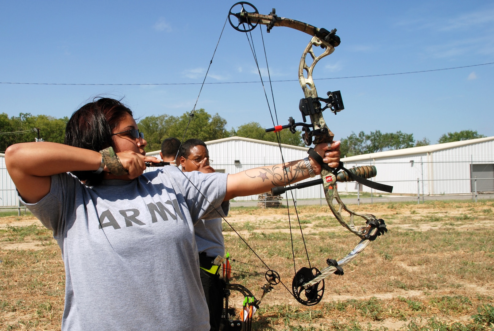 Wounded warrior Spc. Amber Tousha tries out archery for the first time during the Warrior Transition Battalion Adapted Sports Day Aug. 15. (Photo by Maria Gallegos, Brooke Army Medical Center Public Affairs)