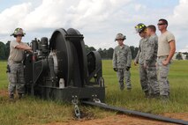 U.S. Air Force Airman 1st Class Zachary Paxson, 4th Civil Engineer Squadron firefighter driver and operator, reels in excess tape using a BAK-12 during a cable engagement exercise on Seymour Johnson Air Force Base, N.C., Aug. 21, 2012. The BAK-12 holds the pendant cable in place to ensure the F-15E Strike Eagle’s hook doesn’t become dislodged during an emergency landing. (U.S. Air Force photo/Airman 1st Class John Nieves Camacho/Released)