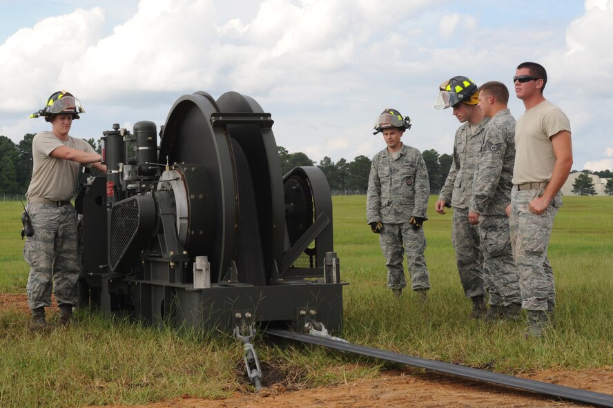 U.S. Air Force Airman 1st Class Zachary Paxson, 4th Civil Engineer Squadron firefighter driver and operator, reels in excess tape using a BAK-12 during a cable engagement exercise on Seymour Johnson Air Force Base, N.C., Aug. 21, 2012. The BAK-12 holds the pendant cable in place to ensure the F-15E Strike Eagle’s hook doesn’t become dislodged during an emergency landing. (U.S. Air Force photo/Airman 1st Class John Nieves Camacho/Released)