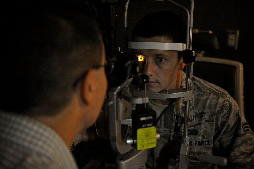 Allan Rhoades, 92nd Aerospace Medicine Squadron optometrist, checks the internal eye health of patient Senior Airman Ilya Demchuk, 92nd Civil Engineer Squadron heating, ventilation, air conditioning and refrigeration technician, during an eye exam in the base optometry clinic at Fairchild Air Force Base, Wash., Aug. 22, 2012. Healthy vision is important in any Air Force job as it enables sound use of operational risk management procedures. (U.S. Air Force photo by Senior Airman Benjamin Stratton)
