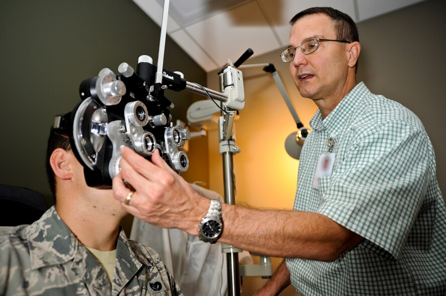 Allan Rhoades, 92nd Aerospace Medicine Squadron optometrist, uses a phoropter during an eye exam of Senior Airman Ilya Demchuk, 92nd Civil Engineer Squadron heating, ventilation, air conditioning and refrigeration technician, in the base optometry clinic at Fairchild Air Force Base, Wash., Aug. 22, 2012. The phoropter is an instrument containing different lenses used for refraction of the eye during sight testing to measure a patient’s refractive error and determine his or her eyeglass prescription. (U.S. Air Force photo by Senior Airman Benjamin Stratton)