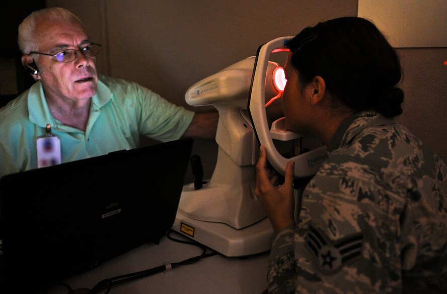 Dale Taylor, 92nd Aerospace Medicine Squadron optometry technician, using a topography machine designed to map the curvature of the eye, assists Senior Airman Danielle Harkins, 92nd Comptroller Squadron budget analyst, as she is fitted for contact lenses in the base optometry clinic at Fairchild Air Force Base, Wash., Aug. 22, 2012. The topography machine is typically used to assess a person’s eye who is a candidate for refractive surgery. (U.S. Air Force photo by Senior Airman Benjamin Stratton)