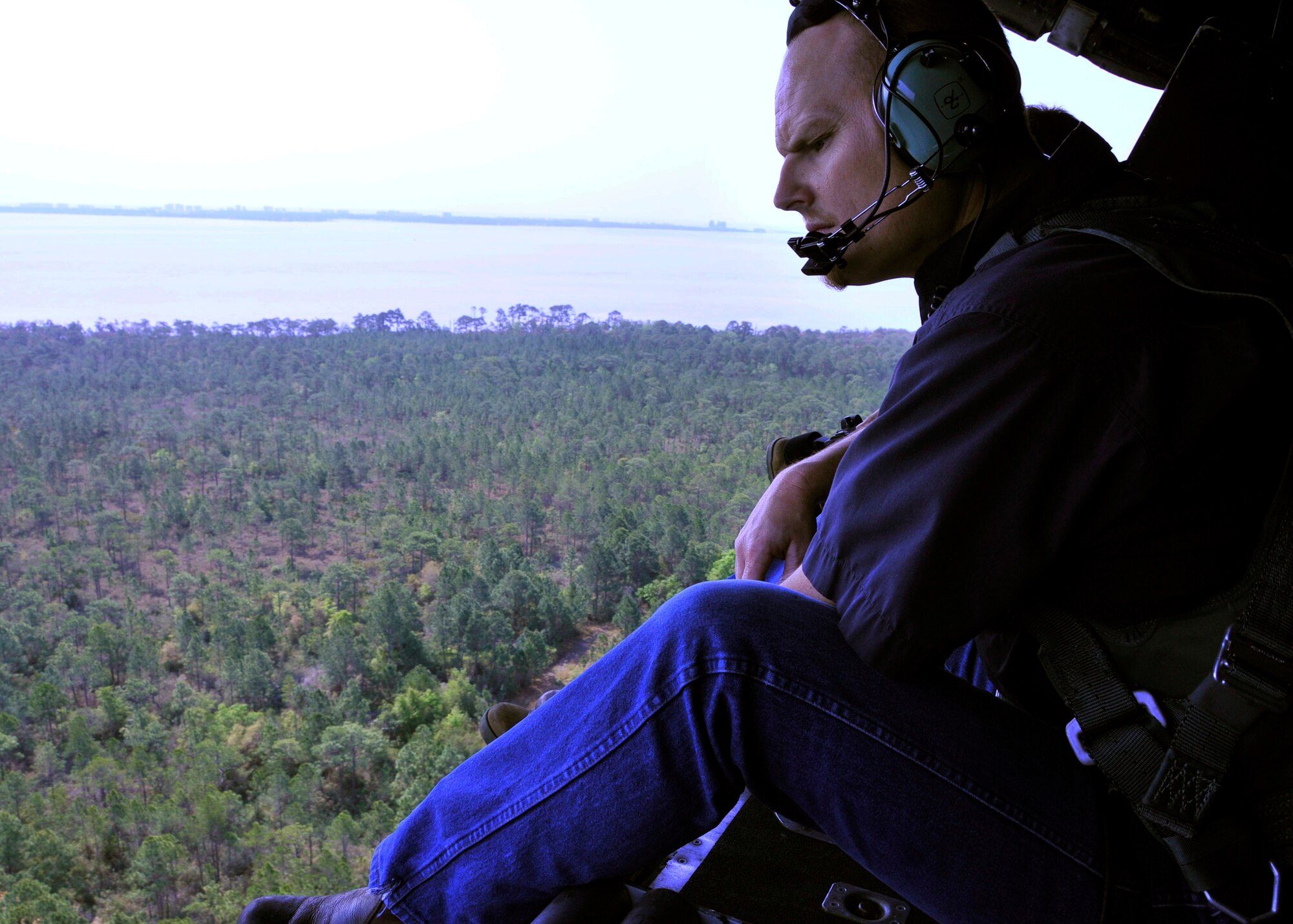 Richard Hinnah, a wildlife biologist from the U.S. Department of Agriculture, searches for eagle nesting sites from the open cargo ramp of a 919th Special Operations Wing MC-130E over Eglin Air Force Base, Fla. The Air Force Reserve wing supported the department’s request for an aerial photography flight to document wildlife habitats near Eglin and Duke Field that can create potential aviation hazards such as bird strikes. (U.S. Air Force photo/Dan Neely)