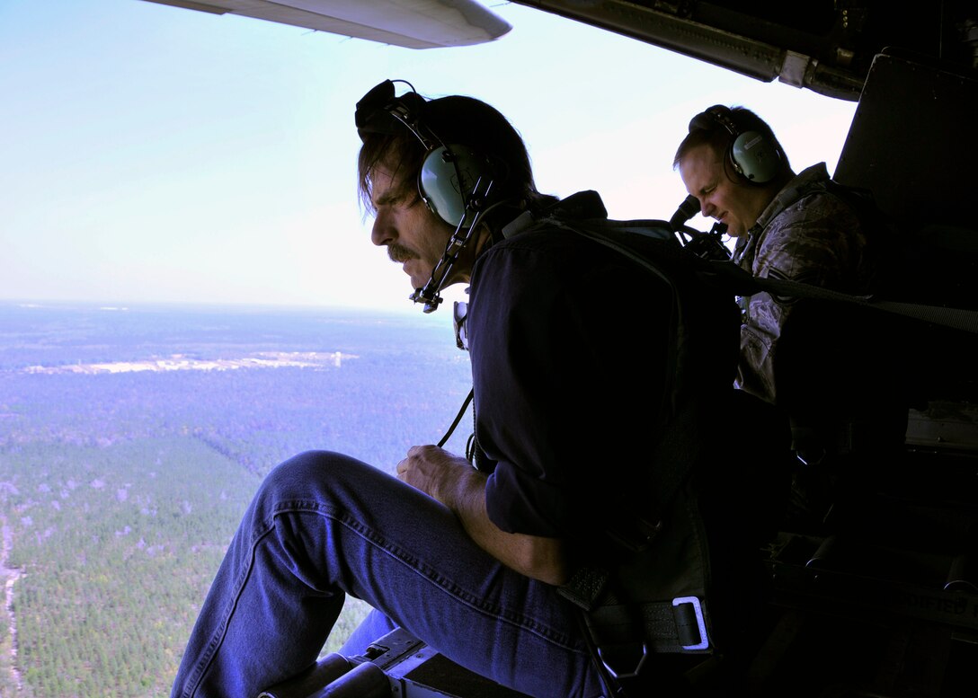 Chris Barre, a wildlife biologist from the U.S. Department of Agriculture, left, searches for eagle nesting sites from the open cargo ramp of a 919th Special Operations Wing MC-130E over Duke Field , Fla., as Tech. Sgt. Jonathan McCallum,  a wing videographer, readies his camera.  The 919th SOW supported the department’s request for an aerial photography flight to document wildlife habitats that can create potential aviation hazards, such as bird strikes, at Duke Field and Eglin Air Force Base, Fla. (U.S. Air Force photo/Dan Neely)¬