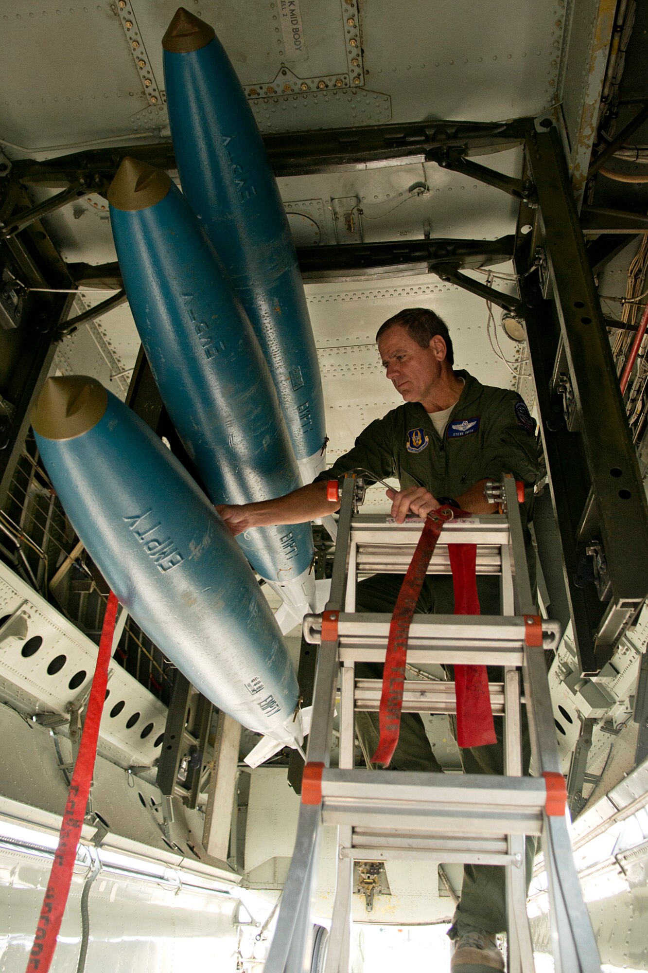 U.S. Air Force Lt. Col. Steve Smith, a 93rd Bomb Squadron radar navigator, removes the safety devices from three 500 lbs BDU-50 general purpose bombs, prior to a sortie on Aug. 21, 2012, Barksdale Air Force Base, La. This sortie was practice for Smith and his crew who are the competition team for the upcoming Global Strike Challenge. (U.S. Air Force photo by Master Sgt. Greg Steele/Released)