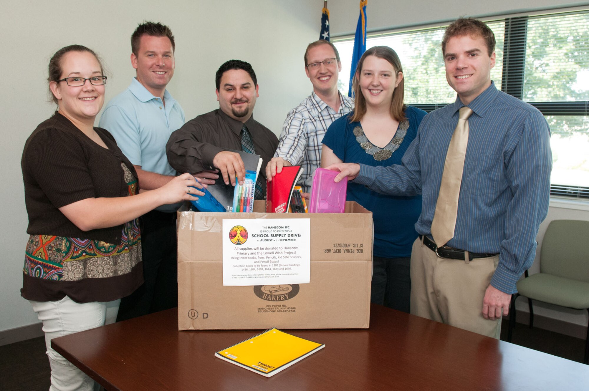 HANSCOM AIR FORCE BASE, Mass. - Members of the Junior Force Council place school supplies in a donation box Aug. 21 as part of the School Supply Drive, which runs now through Sept. 21. All school supplies will be given to Hanscom Primary School and the Lowell Wish Project. Look for donation boxes in buildings around the base. (U.S. Air Force photo by Rick Berry)