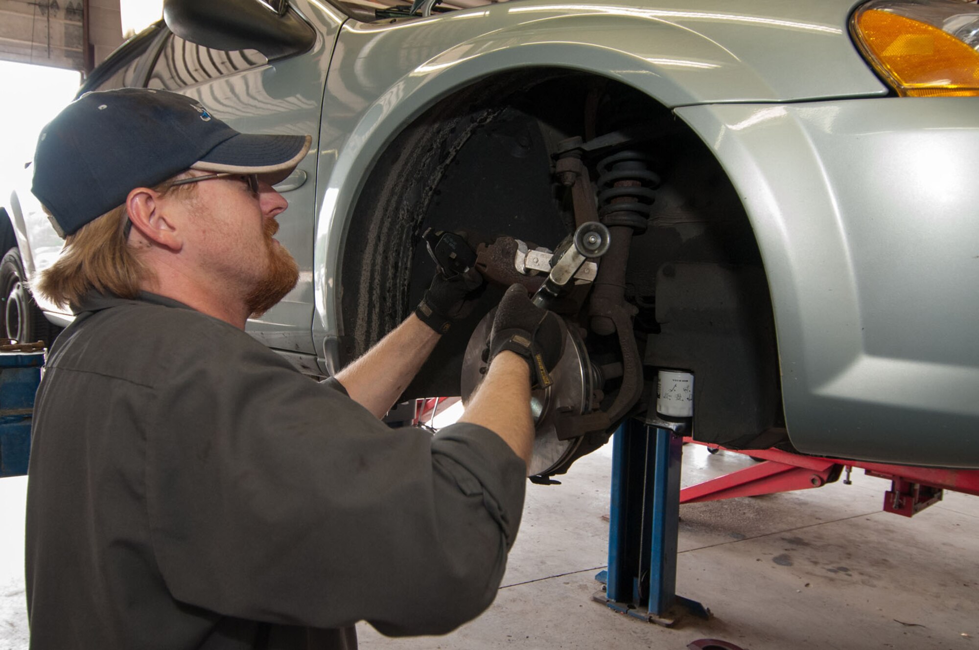 HANSCOM AIR FORCE BASE, Mass. - Tom McElhinny, Auto Skills Center mechanic, uses a caliper piston retractor tool while replacing brakes on a vehicle Aug. 20. The Auto Skills Center offers customers a spacious facility equipped with four swing-arm lifts, one drive on lift, a large selection of tools and a general repair area. Hours of operation are: Monday, 8 a.m. to 5:30 p.m.; Tuesday through Friday, 8 a.m. to 6 p.m.; and Saturday, 8 a.m. to 4 p.m. (U.S. Air Force photo by Rick Berry)
