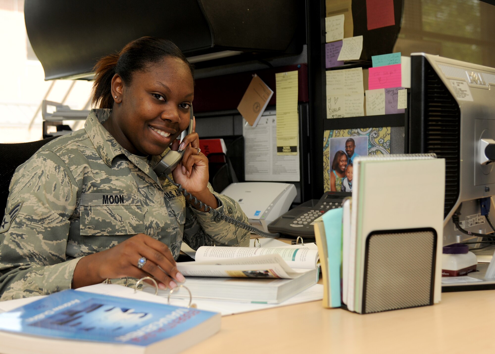 Senior Airman Meshala Moon, 319th Force Support Squadron career development technician, keeps a smile while juggling work and education, Aug. 22, 2012, on Grand Forks Air Force Base, N. D. Moon is in charge of various paperwork aspects of every Grand Forks Airman’s life such as re-enlistments, promotions and retirements and is pursuing a Bachelor of Arts degree in human resource management. (U.S. Air Force photo/Airman 1st Class Ashley N. Taylor)