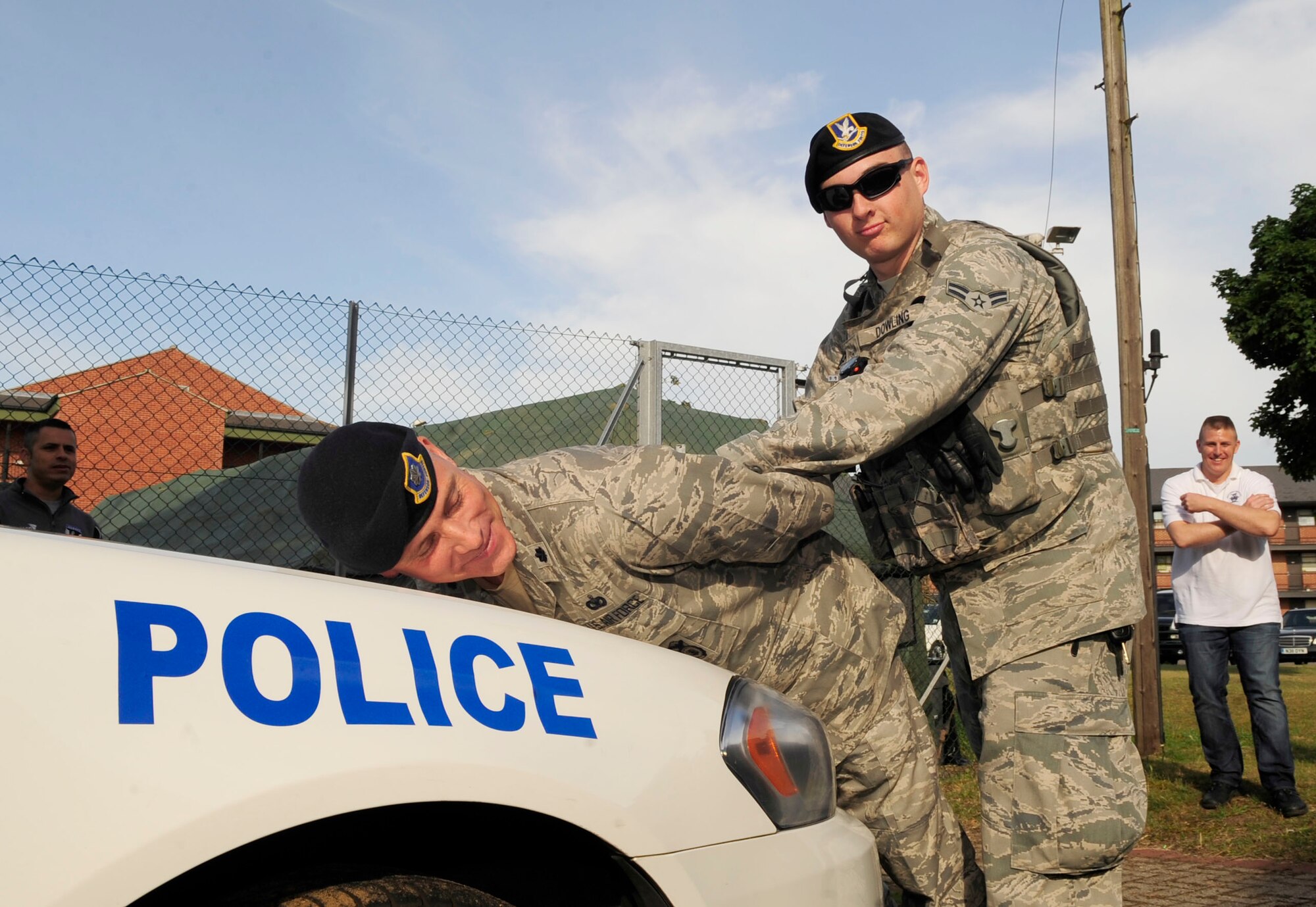 RAF MILDENHALL, England – Airman 1st Class Patrick Dowling, 100th Security Forces Squadron patrolman, places Lt. Col. David Harris, 100th SFS commander, on the hood of a patrol car after arresting him during a “Jail and Bail” Aug. 23, 2012, at RAF Mildenhall. In addition to “Jail and Bail,” the Unaccompanied Airmen Appreciation Day included dodge ball, a dunk tank, free food, live music and other events for the Airmen to enjoy. (U.S. Air Force photo/Senior Airman Ethan Morgan) 