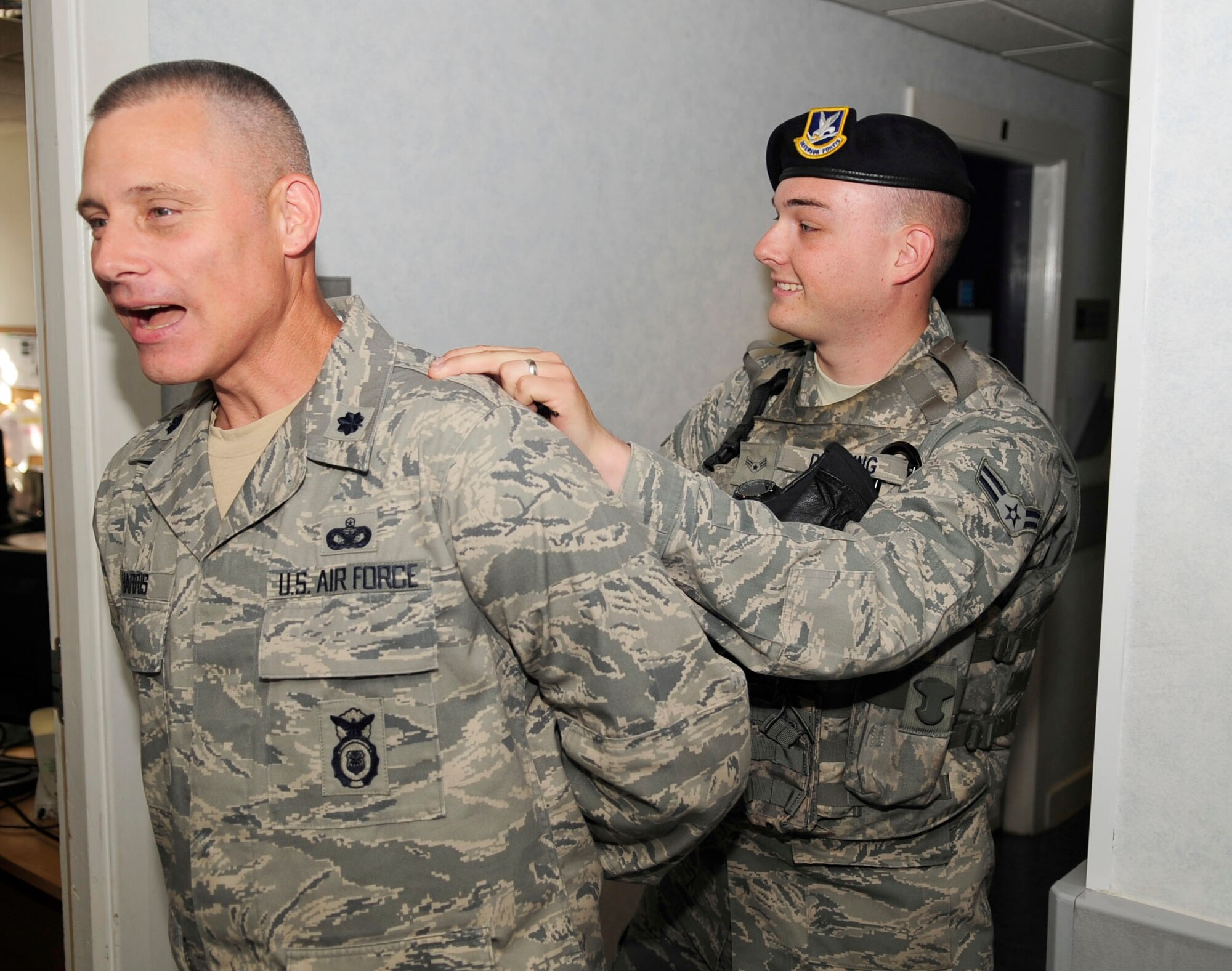 RAF MILDENHALL, England – Airman 1st Class Patrick Dowling, 100th Security Forces Squadron patrolman, leads Lt. Col. David Harris, 100th SFS commander, out of the 100th SFS building after arresting him during a “Jail and Bail” Aug. 23, 2012, at RAF Mildenhall. The “Jail and Bail” was part of the Unaccompanied Airmen Appreciation Day. (U.S. Air Force photo/Senior Airman Ethan Morgan) 