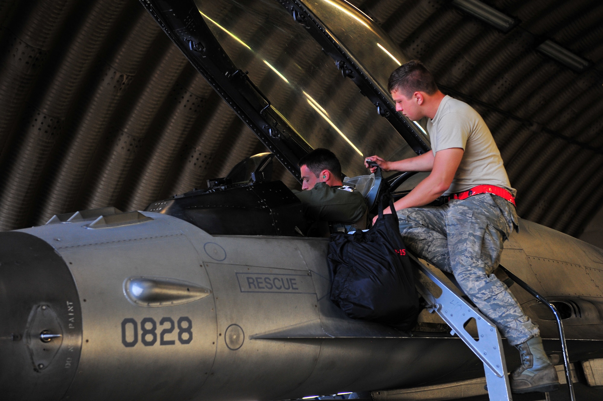 SPANGDAHLEM AIR BASE, Germany – Airman 1st Class Andrey Vasilchuk, 480th Aircraft Maintenance Unit crew chief, helps Capt. Matthew Clayton, 480th Fighter Squadron pilot, get secured into the cockpit of an F-16 Fighting Falcon on the flight line here Aug. 23 before departing for Nordic Air Meet 2012. The fighter squadron departed for the multi-national training exercise to share and exchange new combat tactics with allied countries. (U.S. Air Force photo by Airman 1st Class Dillon Davis/Released)