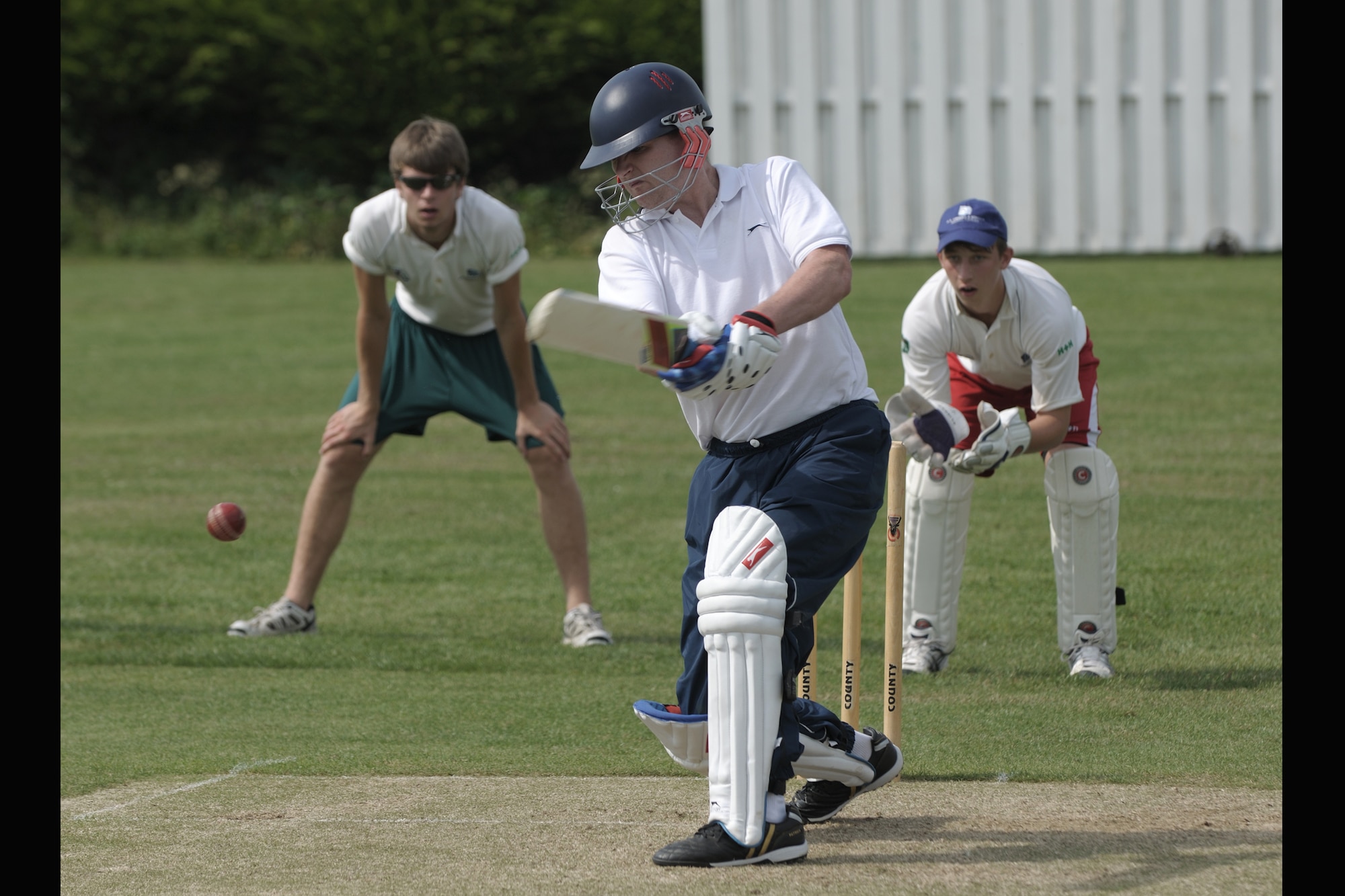 LONGSTANTON, United Kingdom – Maj. Randy Leach, 423rd Medical Squadron, swings for the ball a Longstanton Grasshopper bowled during the first game played by the team Aug. 19 at Longstanton Bowls Club in Longstanton, United Kingdom. Behind each batsman is a target called a wicket. One designated member of the fielding team, the bowler, is given a ball and attempts to bowl the ball from one end of the pitch to the wicket behind the batsman on the other side of the pitch. The batsman tries to prevent the ball from hitting the wicket by striking the ball with a bat. If the bowler succeeds in hitting the wicket, or if the ball, after being struck by the batsman, is caught by the fielding team before it touches the ground, the batsman is dismissed. (U.S. Air Force photo by Master Sgt. John Barton)