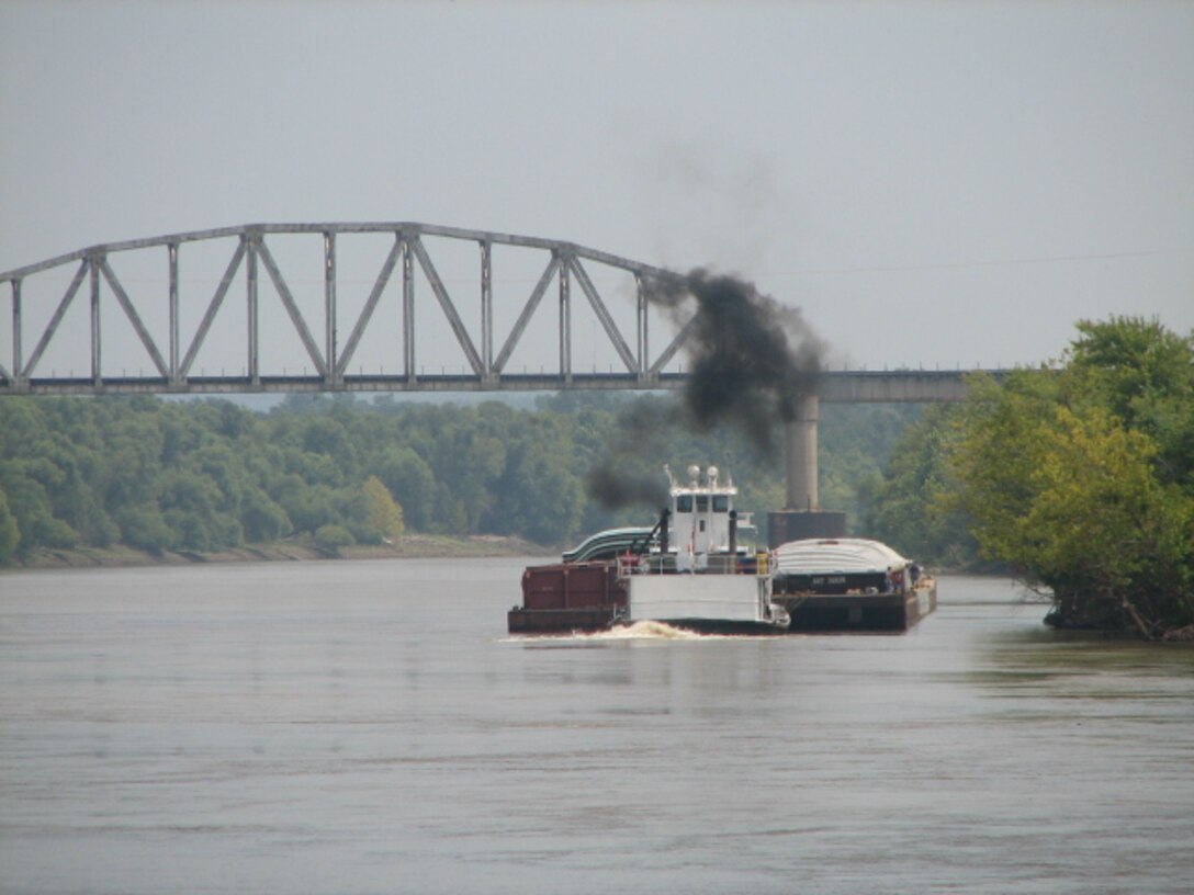 A tug boat pushes barges upstream below Highway 51 bridge near Wagoner, OK.