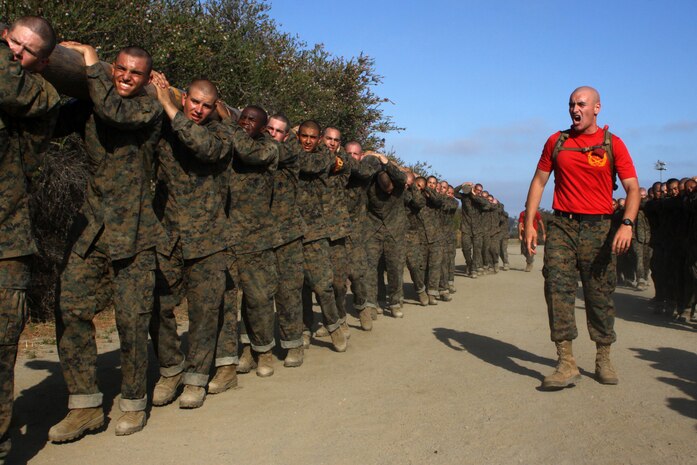 Sgt. Christopher G. Woidt, drill instructor, Platoon 1001, Company A, 1st Recruit Training Battalion, motivates recruits as they execute log drills during recruit training aboard Marine Corps Recruit Depot San Diego Aug. 14. Recruits performed drills over the course of half a mile such as side benders, log curls and log-lifts.