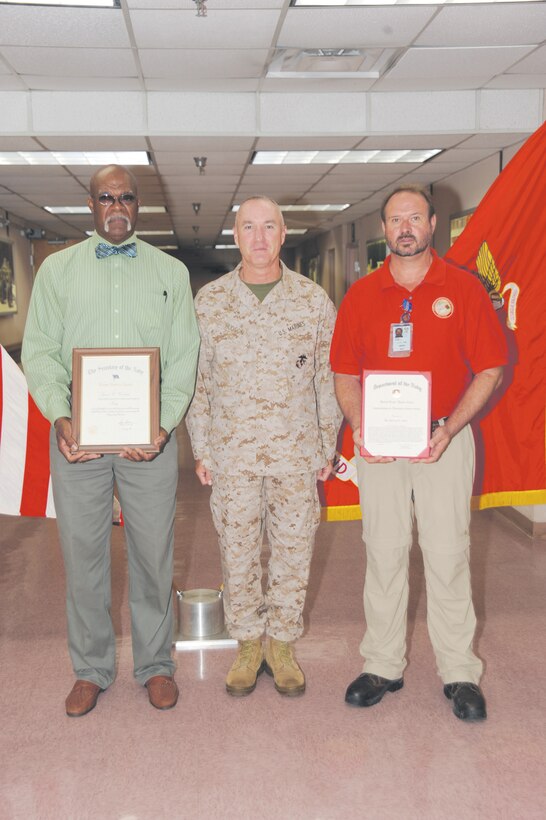 Maj. Gen. Charles Hudson, commanding   general, Marine Corps Logistics Command,  center, poses with Lymas Cowling, left, and Steven Allen during an awards ceremony at Marine Depot Maintenance Command’s lobby, Aug. 7.