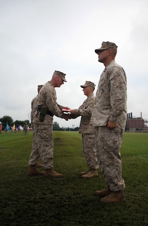 Philadelphia native Cpl. Jason M. Hassinger (center right), receives the Silver Star from Maj. Gen. John A. Toolan, the outgoing commanding general of 2nd Marine Division during the 2nd Marine Division change-of-command ceremony Aug. 23 aboard Camp Lejeune. Hassinger received the Silver Star for his actions during an ambushed patrol in Marjah, Helmand province, Afghanistan, in which he led his section through intense fire to rescue a group of fellow Marines pinned down by the enemy.  Hassinger was shot four times during the incident but continued to fight until the enemy retreated. The Silver Star is the third-highest award a U.S. service member can receive for valor in combat.