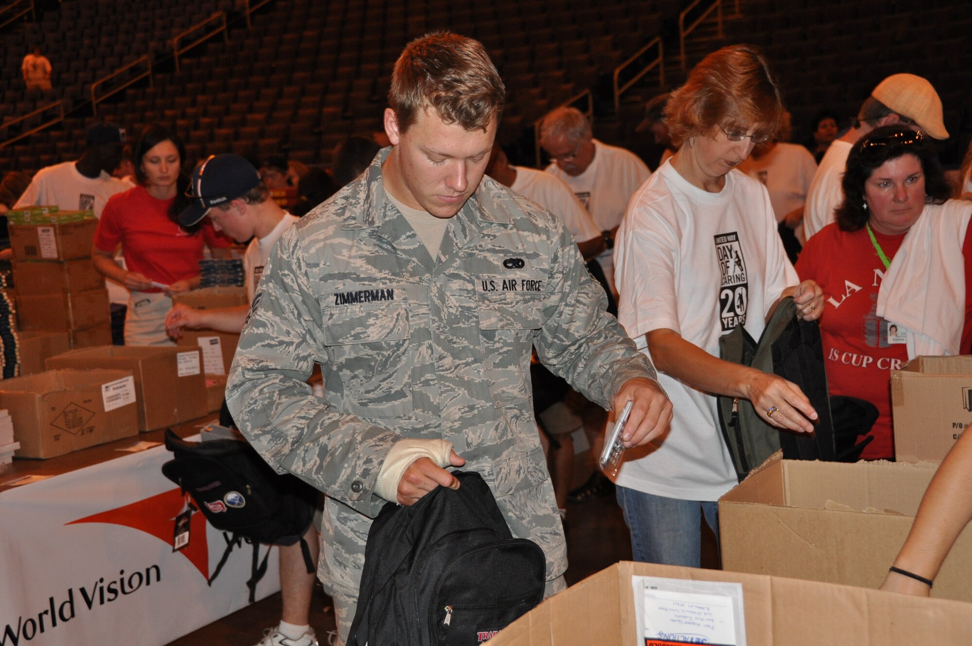 BUFFALO, N.Y. - Senior Airman Jackson Zimmerman, 107th Maintenance Squadron, fills a backpack with donated school supplies at First Niagara Arena August 15.  Several volunteers from the 914th and 107th Airlift Wings volunteered their time to help in the 20th annual United Way Day of Caring.  As just one part of the overall Day of Caring, over 100 volunteers gathered in the arena to fill 4,000 backpacks which will be given to needy local area school children.  (U.S. Air Force photo by Master Sgt. Kevin Nichols)