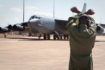 A United States Air Force loadmaster gives final signals to the crew of a B-52 as it begins shutdown procedures at RAAF Base Darwin.  The Royal Australian Air Force is pleased to welcome a United States Air Force (USAF) B-52 and KC-135 from Andersen Air Force Base, Guam, to RAAF Base Darwin.  The USAF crew will conduct routine training in RAAF Base Darwin.  On departure from Darwin the B-52 will fly via Delamere Air Weapons Range to simulate ordnance drops with RAAF and practice aerial refueling operations.  This demonstrates Australia's commitment to increased cooperation with the United States.  Both nations share an intent for increased U.S. Air Force training with the RAAF, however decisions on future rotations including timings are still under discussion.  This is the first time a B-52 has landed at RAAF Darwin and since the United States and Australia announced enhanced aircraft cooperation as one of the two force postures initiatives, in November 2011.  (Courtesy photo)