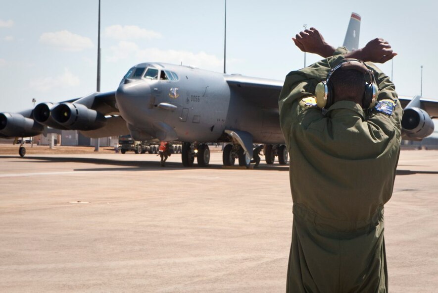 A United States Air Force loadmaster gives final signals to the crew of a B-52 as it begins shutdown procedures at RAAF Base Darwin.  The Royal Australian Air Force is pleased to welcome a United States Air Force (USAF) B-52 and KC-135 from Andersen Air Force Base, Guam, to RAAF Base Darwin.  The USAF crew will conduct routine training in RAAF Base Darwin.  On departure from Darwin the B-52 will fly via Delamere Air Weapons Range to simulate ordnance drops with RAAF and practice aerial refueling operations.  This demonstrates Australia's commitment to increased cooperation with the United States.  Both nations share an intent for increased U.S. Air Force training with the RAAF, however decisions on future rotations including timings are still under discussion.  This is the first time a B-52 has landed at RAAF Darwin and since the United States and Australia announced enhanced aircraft cooperation as one of the two force postures initiatives, in November 2011.  (Courtesy photo)