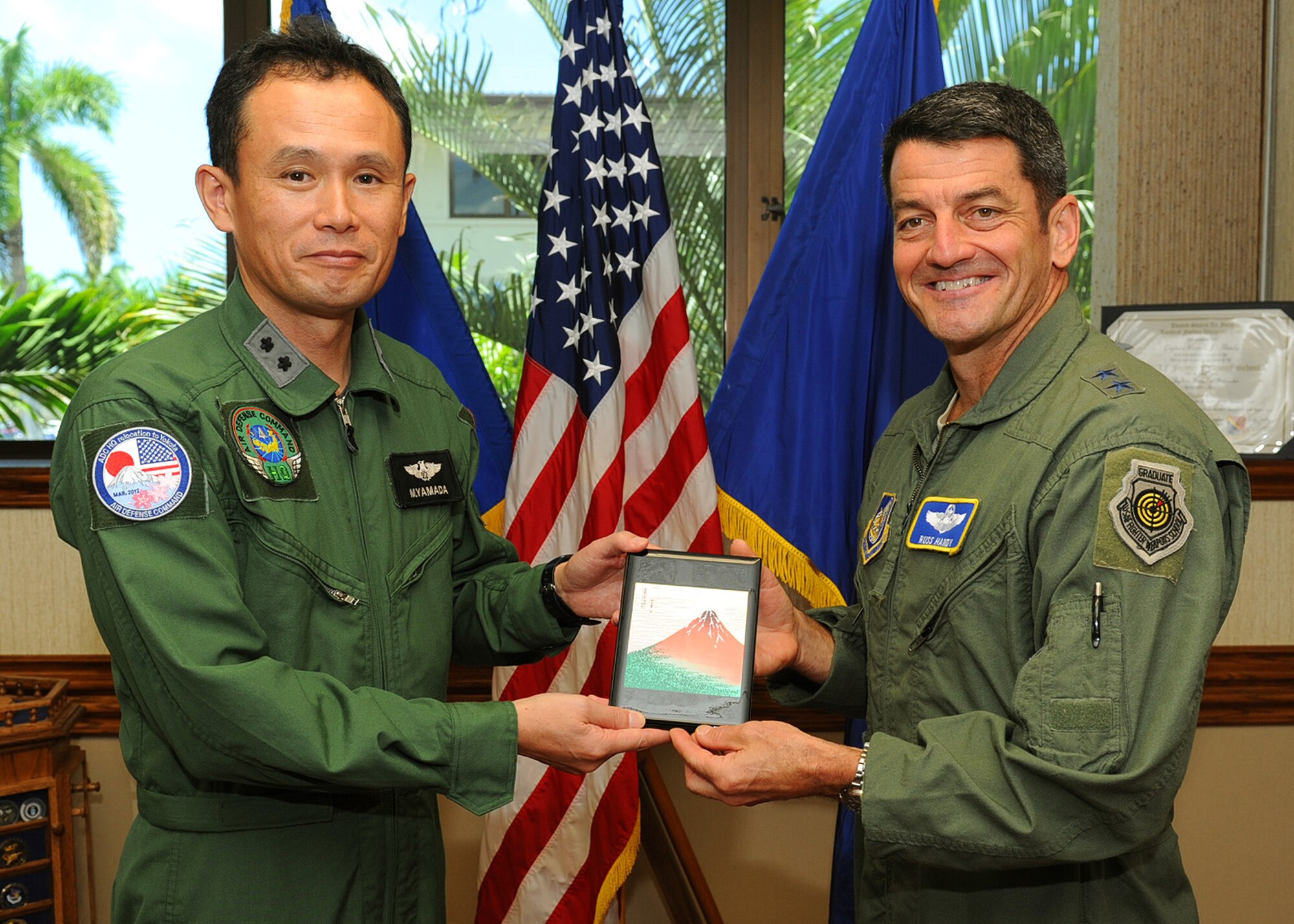 Maj. Gen. Misashi Yamada, Director of Defense Plans and Operations Directorate, Air Defense Command, Japan Air Self-Defense Force, presents a gift to Maj. Gen. Russell J. Handy, Pacific Air Forces Director of Operations, Plans, Requirements and Programs, during a visit to the PACAF headquarters building, Joint Base Pearl Harbor-Hickam, Hawaii, Aug. 22, 2012. Yamada visited with Handy to discuss the 13th Air Force inactivation scheduled for Sept. 28, 2012, and the two explored new ways to continue efforts to enhance interactions between the 613th Air and Space Operations Center and the Japanese AOC. (U.S. Air Force photo/Tech. Sgt. Jerome S. Tayborn)