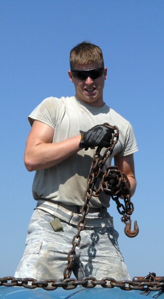 Senior Airmen David Andrews, 2nd Munitions Squadron munitions maintenance team, chains down inert Mark 82 low drag unguided bombs after they were loaded onto one of four tractor trailers on Barksdale Air Force Base, La. Aug. 20. The Mark 82 load is one of the events that the 11-person munitions maintenance team load competes in as part of the 2012 Global Strike Challenge. (U.S. Air Force photo/Staff Sgt. Jason McCasland)(RELEASED)
