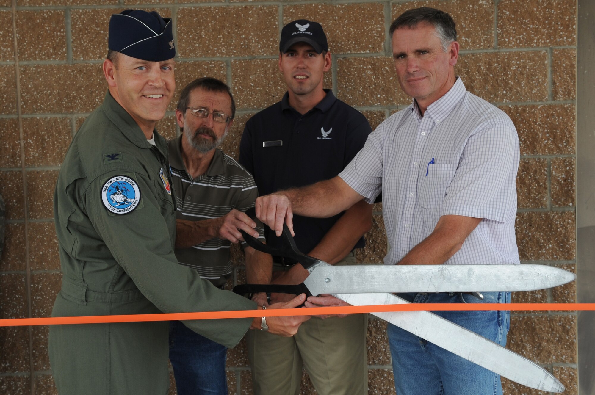 U.S. Air Force Col. Chris Short, 366th Fighter Wing commander, cuts a ribbon with individuals who assisted with the renovation of the Fitness Center Annex Aug. 12, 2012 at Mountain Home Air Force Base, Idaho. The annex is in alternative testing facility in case of inclement weather. (U.S. Air Force photo/Staff Sgt. Roy Lynch)