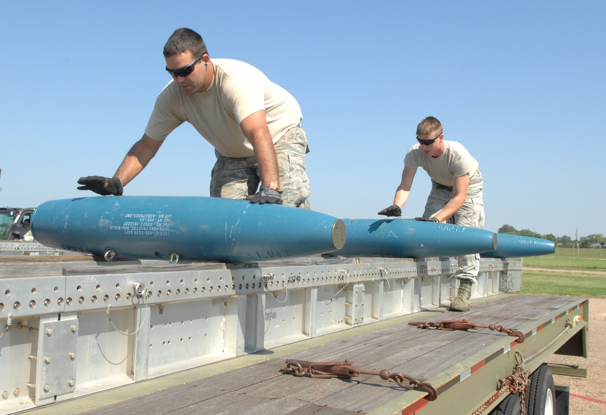 Staff Sgt. Russell Fenimore and Senior Airmen David Andrews, both from 2nd Munitions Squadron munitions maintenance team, roll inert Mark 82 low drag unguided bombs onto a tractor trailer on Barksdale Air Force Base, La., Aug 20. The Mark 82 low drag unguided bomb roll is part of the 2012 Global Strike Challenge where the 11-person munitions maintenance team will load 162 bombs onto four tractor trailers. (U.S. Air Force photo/Staff Sgt. Jason McCasland)(RELEASED)
