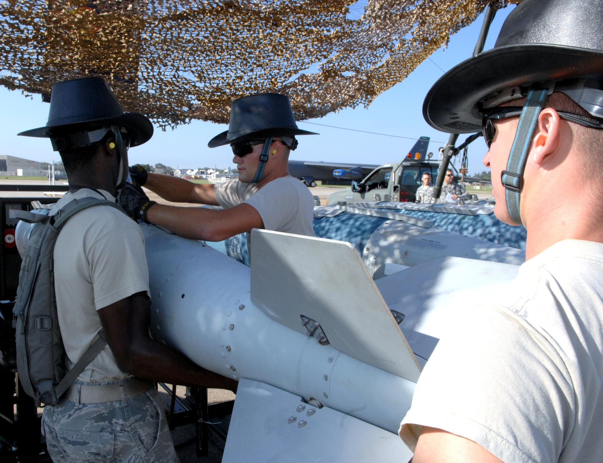 Three members of the 2012 Global Strike Challenge munitions maintenance team from the 2nd Munitions Squadron install a tail fin assembly to an inert two-thousand pound GPS guided GBU-31 version one bomb on Barksdale Air Force Base, La., Aug 20. The GBU-31 FMU-152 fuse, nose cone and tail fins are installed while on the track. The track provides a mobile workstation that the bombs can be built on and then transferred to a trailer. (U.S. Air Force photo/Staff Sgt. Jason McCasland)(RELEASED)