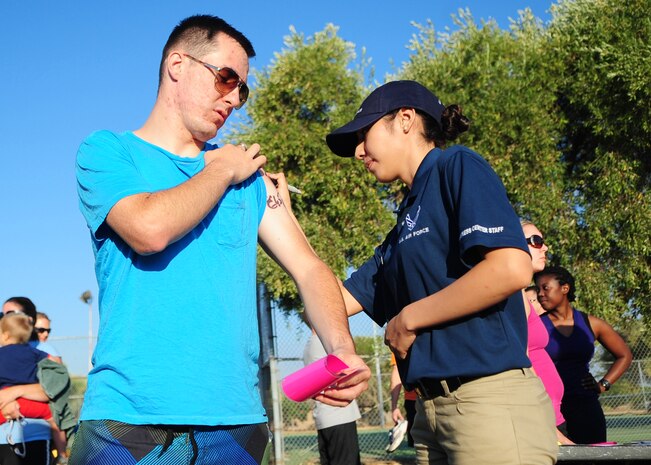Senior Airman Cindy Valadez, 9th Force Support Squadron fitness specialist, labels a participant in the Recce Challenge Sprint Triathlon August 23, 2012 at Beale Air Force Base, Calif. The event gave Airmen the opportunity to test their physical endurance while promoting the fit-to-fight mindset of the Air Force. (U.S. Air Force photo by Senior Airman Shawn Nickel/Released)