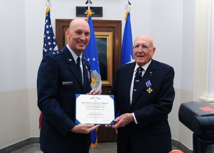 Maj. Gen. Timothy Zadalis (left), Air Education and Training Command director of Intelligence, Operations and Nuclear Integration, presents the Distinguished Flying Cross to former Army Air Corps 2nd Lt. Samuel  W.  Smith, 360th Bombardment Squadron B-17 aircraft commander, during a ceremony at Bldg. 100 at Joint Base San Antonio-Randolph Aug. 24. During WWII, Lieutenant Smith's display of exemplary knowledge and outstanding Airmanship under extreme and hazardous conditions culminated in the successful landing of his damaged aircraft upon a return from a mission to Hopston, Germany. (U.S. Air Force photo by Rich McFadden)