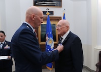 Maj. Gen. Timothy Zadalis (left), Air Education and Training Command director of Intelligence, Operations and Nuclear Integration, presents the Distinguished Flying Cross to former Army Air Corps 2nd Lt. Samuel  W.  Smith, 360th Bombardment Squadron B-17 aircraft commander, during a ceremony at Bldg. 100 at Joint Base San Antonio-Randolph Aug. 24. During WWII, Lieutenant Smith's display of exemplary knowledge and outstanding Airmanship under extreme and hazardous conditions culminated in the successful landing of his damaged aircraft upon a return from a mission to Hopston, Germany. (U.S. Air Force photo by Rich McFadden)