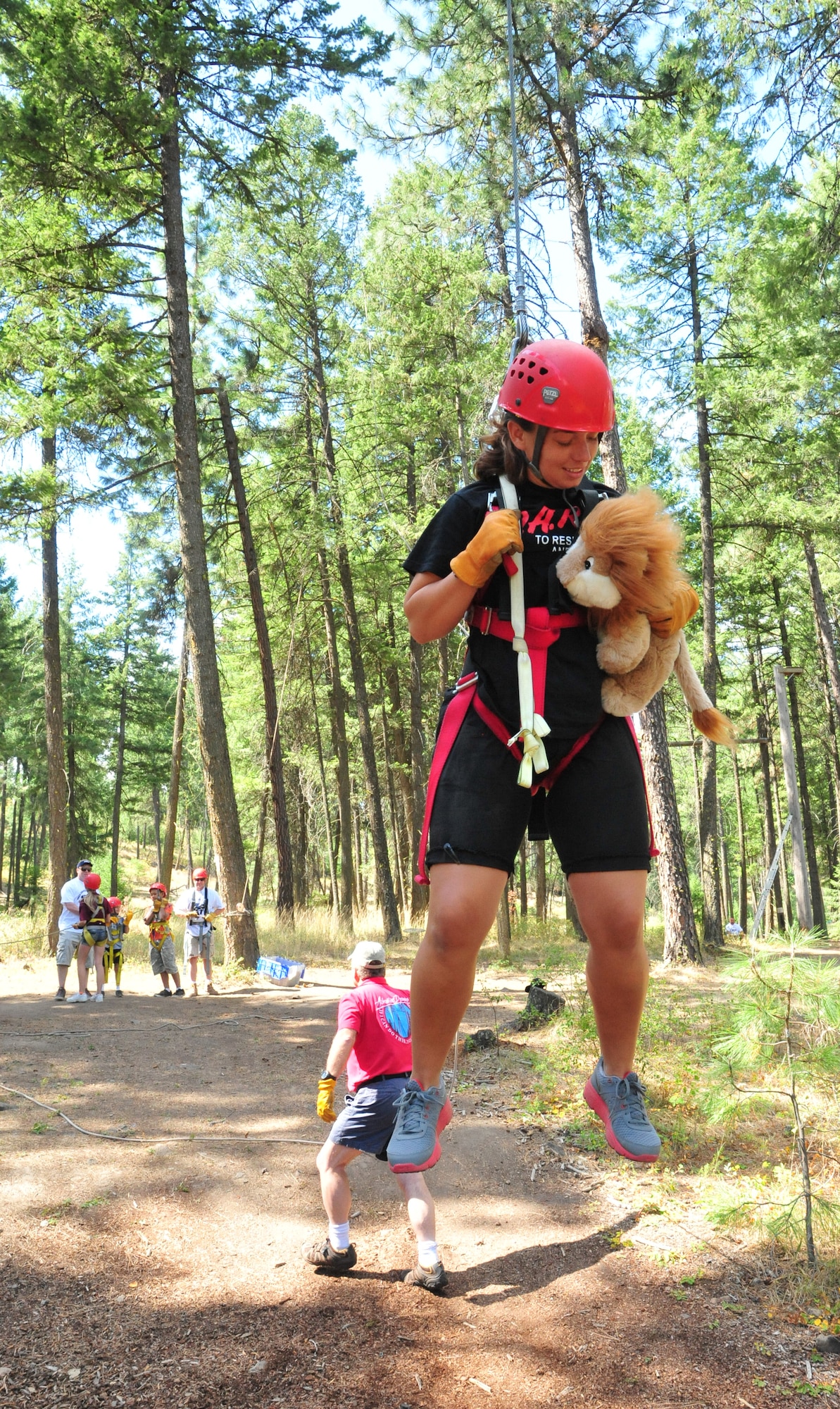 Staff Sgt. Brooke Williams, 92nd Security Forces Squadron member and hosts of this year’s D.A.R.E. summer camp, holds Daren while Will Parks, Adventure Dynamics instructor, tell others to pull the rope, which lifts Williams in the air so she can experience the zip-line swing Aug. 22, 2012 at Adventure Dynamics in Nine Mile Falls, Washington. (U.S. Air Force photo by Airman 1st Class Earlandez Young)   
