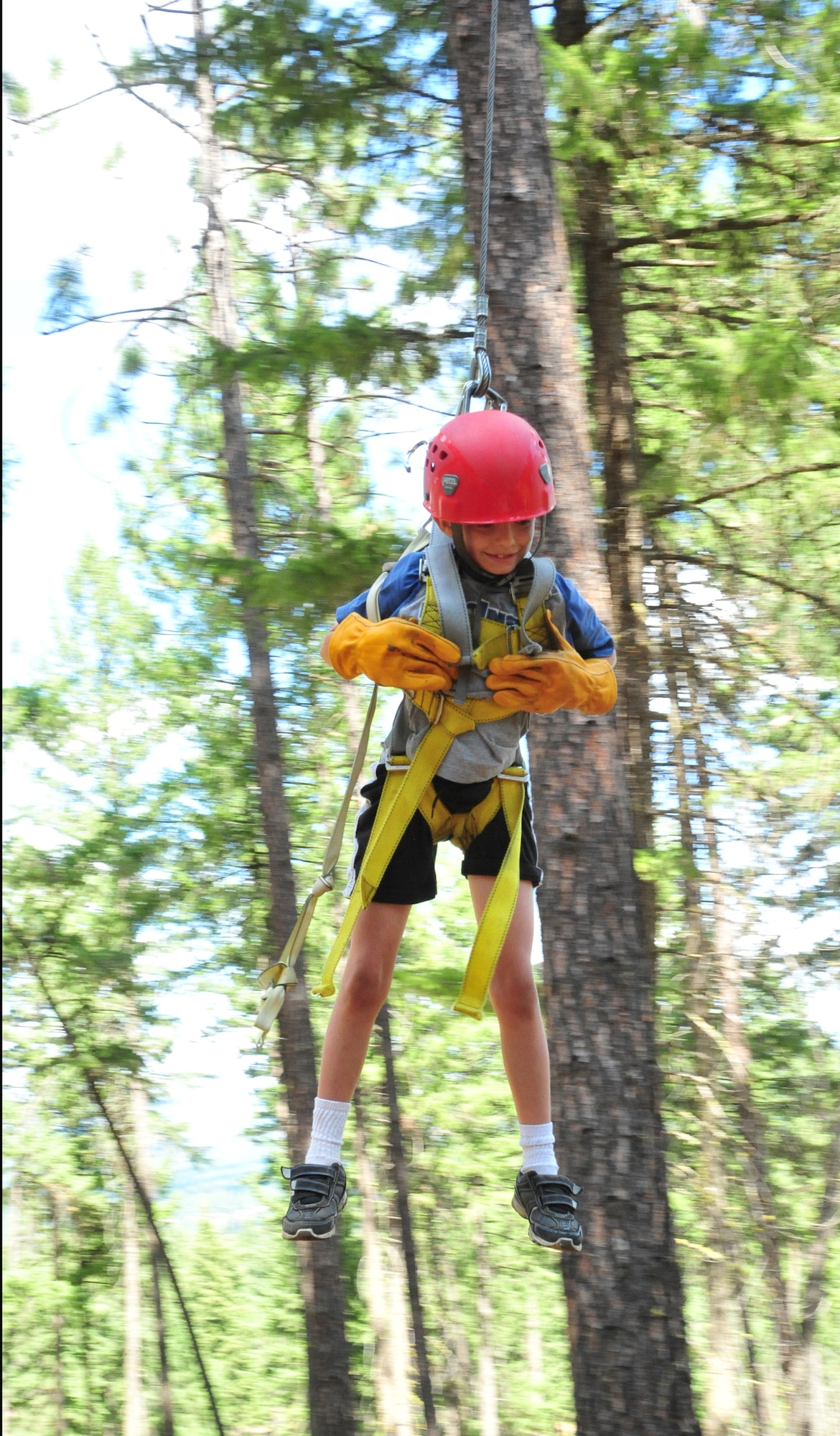 Dalton, a member of the D.A.R.E. summer camp, glides in the air as he is locked in a harness attached to a zip-line swing Aug. 22, 2012 at Adventure Dynamics in Nine Mile Falls, Washington. (U.S. Air Force photo by Airman 1st Class Earlandez Young)  