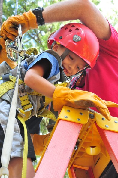 Dalton, a member of the D.A.R.E. summer camp, smiles anxiously as Adventure Dynamics instructor Will Parks hooks his harness up to the zip-line swing Aug. 22, 2012 at Adventure Dynamics in Nine Mile Falls, Washington. (U.S. Air Force photo by Airman 1st Class Earlandez Young)  