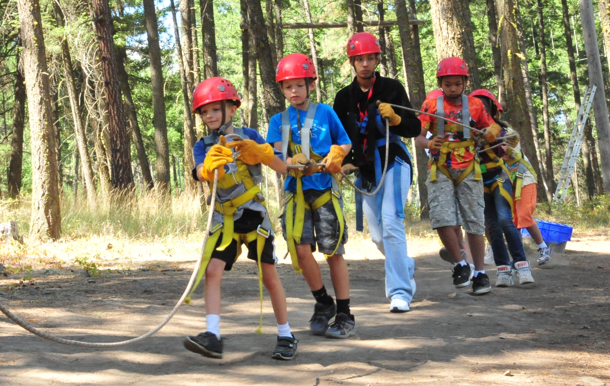 Members of the D.A.R.E. summer camp pull a rope connected to the zip-line swing Aug. 22, 2012 at Adventure Dynamics in Nine Mile Falls, Washington. When the rope is pulled, the individual on the zip-line swing goes in the air. This is Adventure Dynamic’s way of demonstrating teamwork. (U.S. Air Force photo by Airman 1st Class Earlandez Young)  