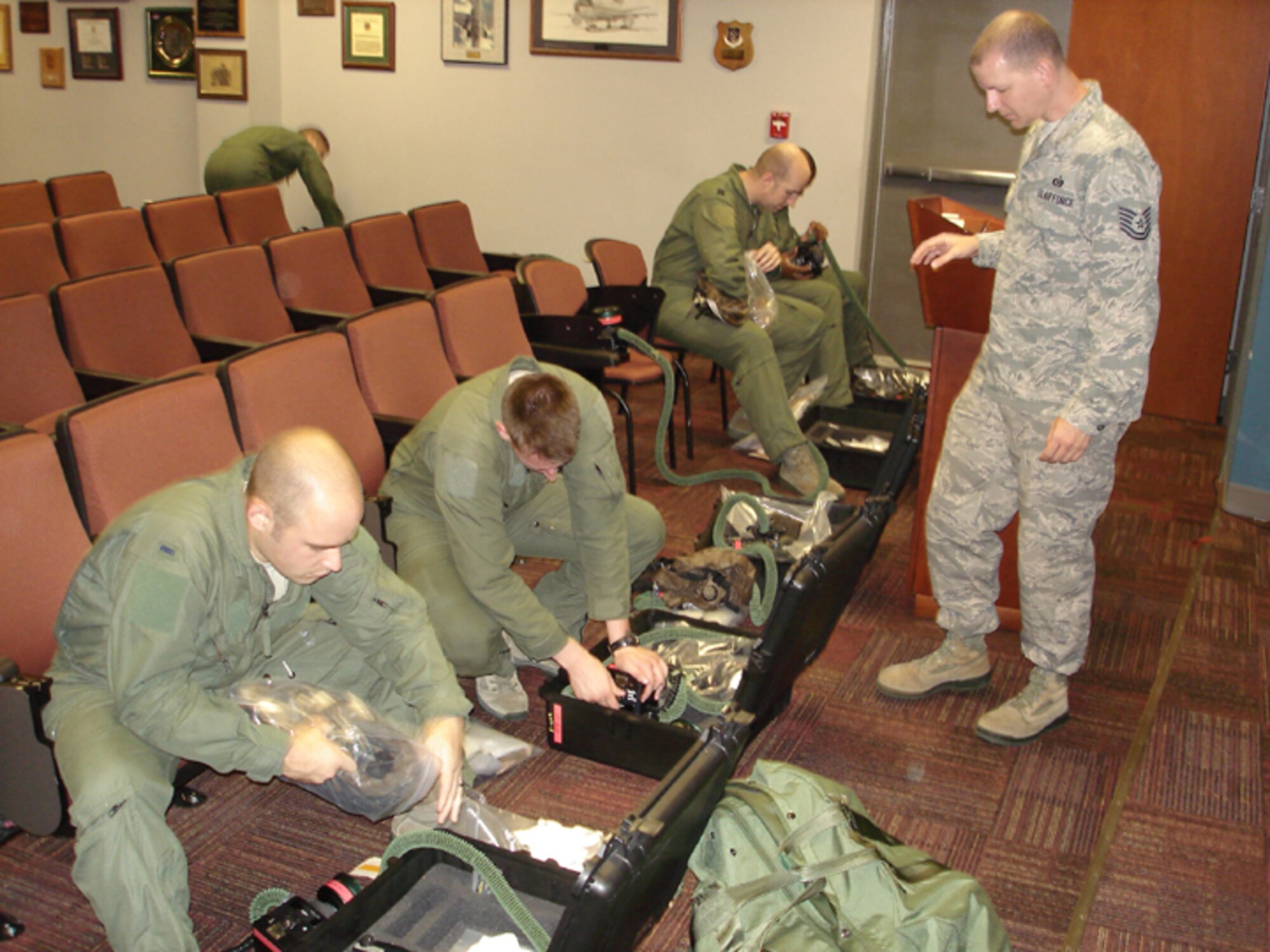 Tech. Sgt, David Bordeaux, 916th Aircrew Flight Equipment, trains an aircrew on the proper wear of their chemical ensemble during an exercise held here in August. (USAF photo by TSgt. Ian Gardner, 916OSS)