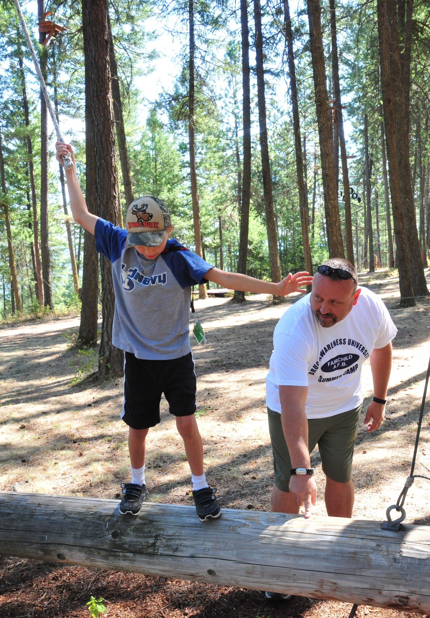 Robert Slayton, member of the 92nd Security Forces Squadron, encourages Dalton to finish the tight rope team challenge Aug. 22, 2012 at Adventure Dynamics in Nine Mile Falls, Washington. Slayton is hosting this year’s D.A.R.E. summer camp along with Staff Sgt. Brooke Williams, who is also a member of the 92nd SFS. (U.S. Air Force photo by Airman 1st Class Earlandez Young)