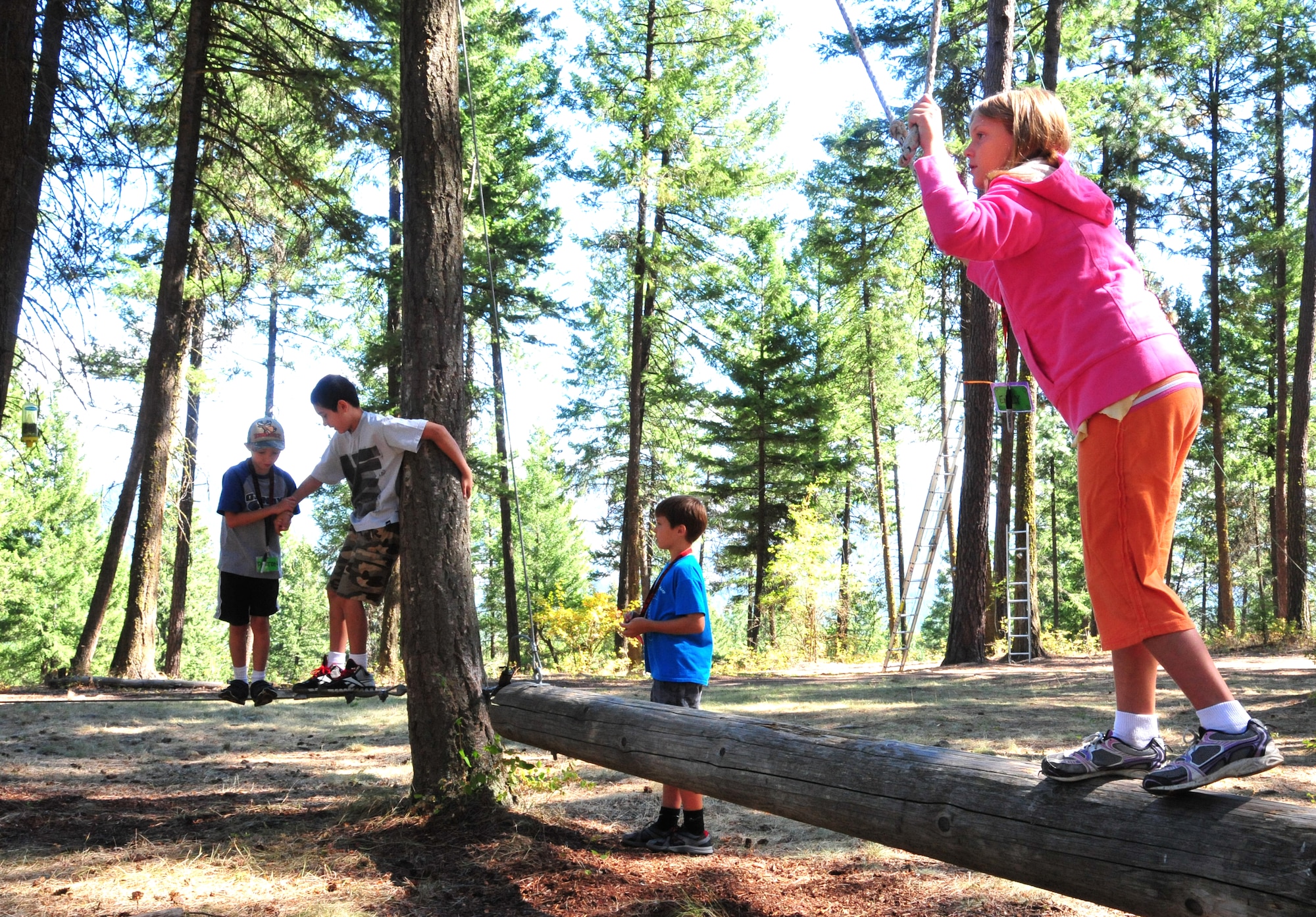 Emily, a member of the D.A.R.E. summer camp, waits at the finish line while Trevor assists Dalton with the last tree pass to complete the tight rope team challenge Aug. 22, 2012 at Adventure Dynamics in Nine Mile Falls, Washington. The three are all members of this year’s D.A.R.E. summer camp. (U.S. Air Force photo by Airman 1st Class Earlandez Young) 