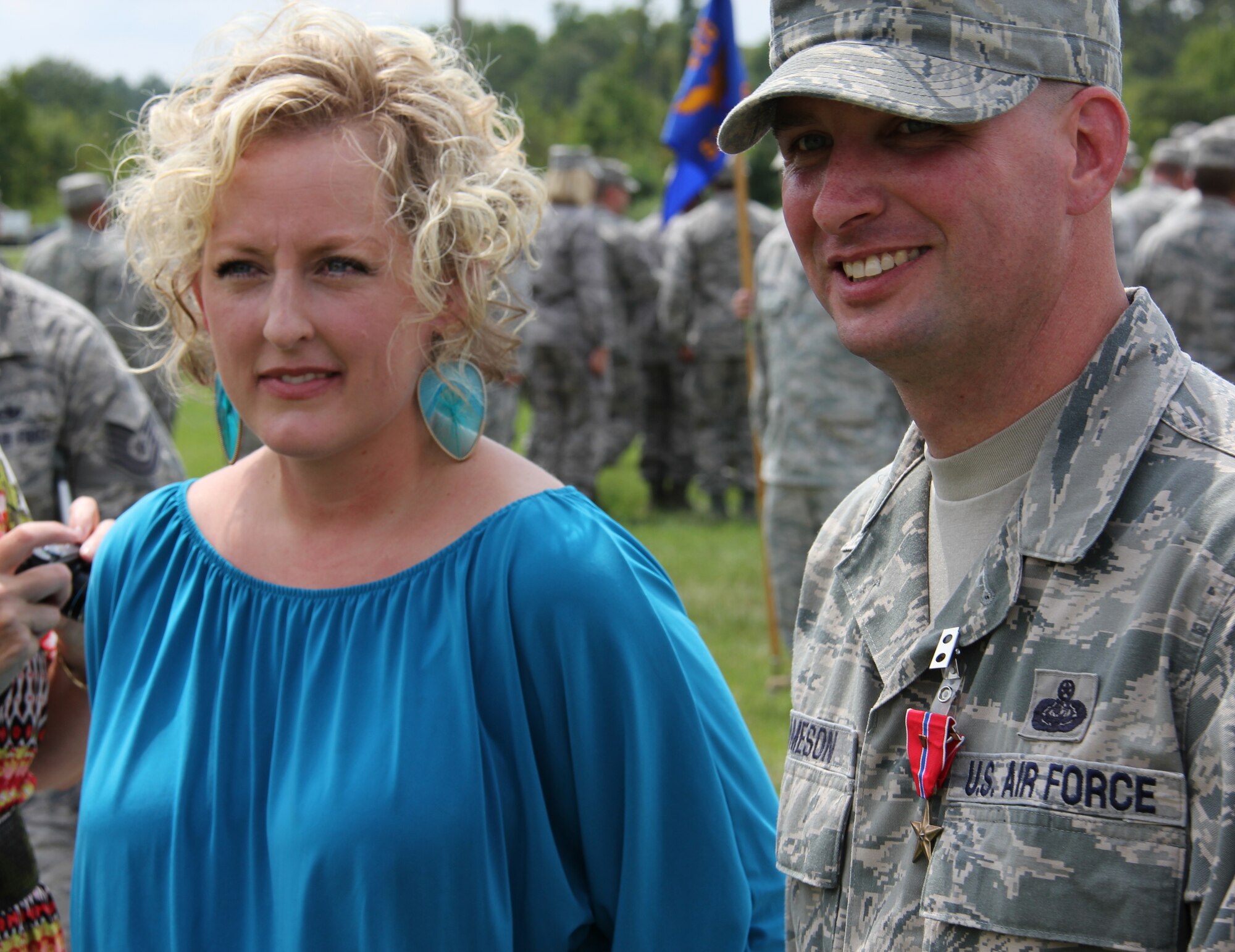 ROBINS AIR FORCE BASE, Ga. -- Master Sgt. Gene Jameson, III, 689th CCW wing policy manager, and his wife Jessica, discuss his Bronze Star with Valor with members of the wing sitting in the stands after the awards ceremony here Aug. 23. Jameson was awarded the medal for his actions while deployed to Bagram, Afghanistan. He battled a fire started by an insurgent’s 107-millimeter rocket. (U.S. Air Force photo by Robert Talenti)