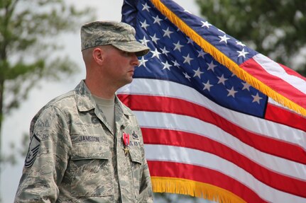 ROBINS AIR FORCE BASE, Ga. -- Master Sgt. Gene Jameson, III, 689th CCW wing policy manager, stands proudly in front of the U.S. flag here August 23. Jameson was awarded the medal for his actions while deployed to Bagram, Afghanistan. He battled a fire started by an insurgent’s 107-millimeter rocket. (U.S. Air Force photo by Robert Talenti)