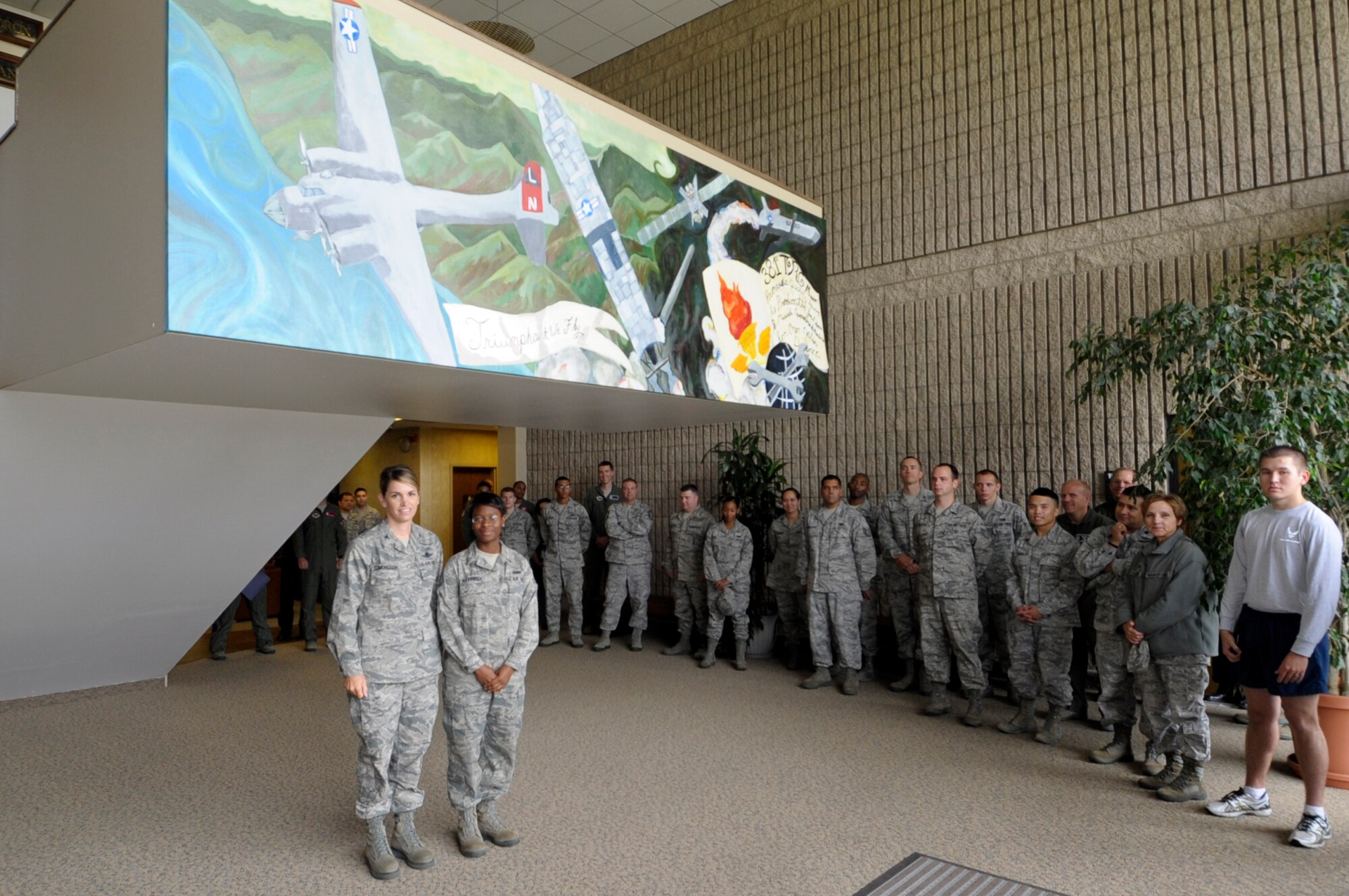 VANDENBERG AIR FORCE BASE, Calif. – Col. Michele Edmonson, 381st Training Group commander, and Airman 1st Class Eboni Alexander, of the 381st Training Support Squadron, pose under the newly reveled mural representing the heritage of the 381st Training Group during a ceremony here, August 23, 2012. Alexander designed the mural and led the team depicting the three main eras of the unit; the 381st Bombardment Group, the 381st Strategic Missile Wing, and the 381st Training Group. (U.S. Air Force photo/Jerry E. Clemens Jr.)