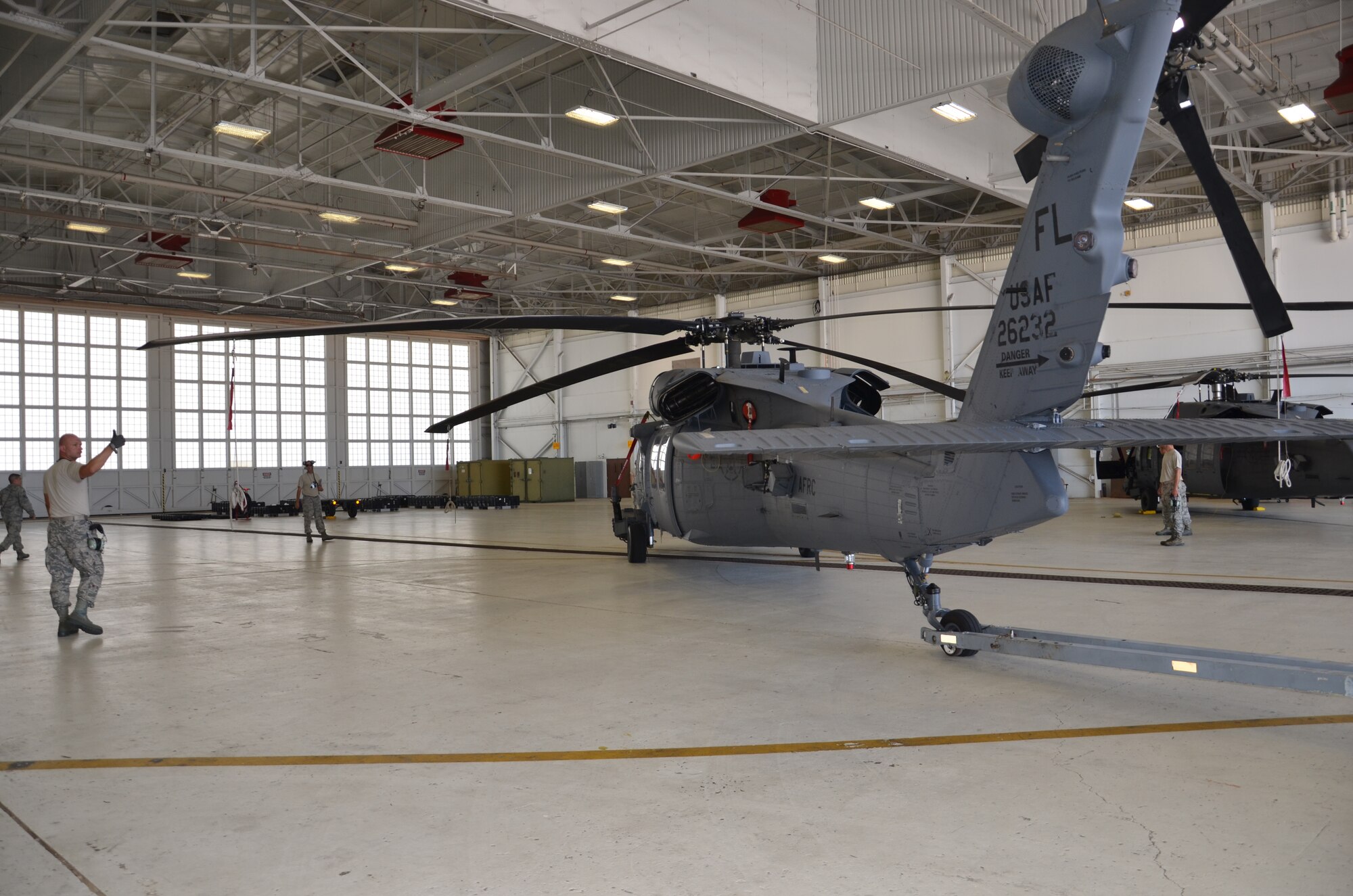An HH-60G Pave Hawk helicopter is marshaled in by Rescue Wing Airmen as high winds threaten the 920th Rescue Wing, Patrick Air Force Base, Fla. According to Staff Sgt. Duane Moccio, HH-60G Pave Hawk helicopter dedicated crew chief, 902th Aircraft Maintenance Squadron, Patrick Air Force Base, Fla., when winds are 45 knots or more, Rescue Wing HH-60 maintainers are required to bring in the five rescue helicopters assigned to the wing. (U.S. Air Force photo/Senior Airman Natasha Dowridge)