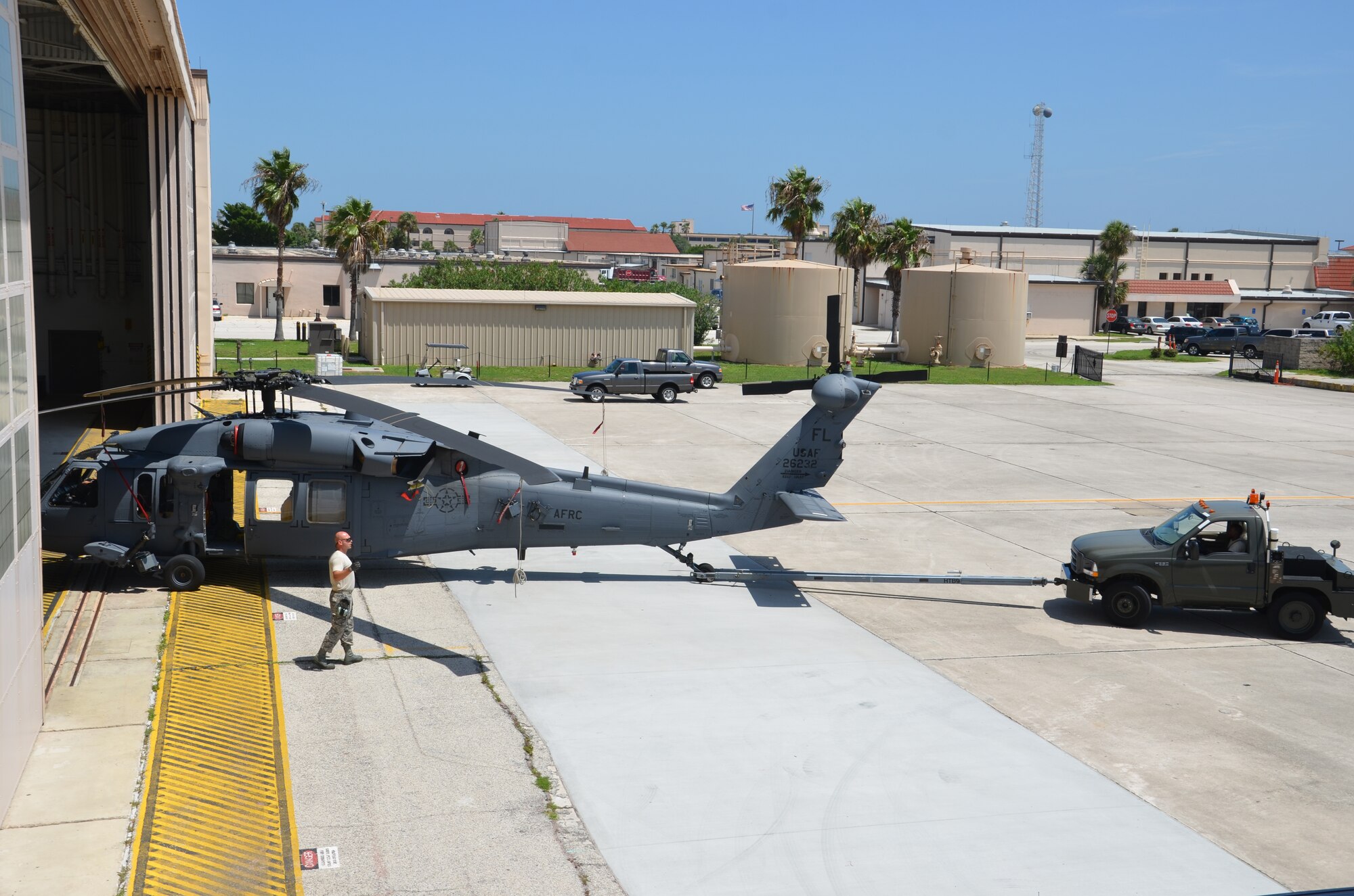 Staff Sgt. Duane Moccio, HH-60G Pave Hawk helicopter dedicated crew chief, 920th Aircraft Maintenance Squadron, Patrick Air Force Base, Fla., marshals a rescue helicopter. As a precautionary measure all Pave Hawks assigned to the 920th Rescue Wing are moved into Hangar 750 to weather out the approaching tropical storm Isaac. "It is standard practice to hangar the choppers when the wind is expected to exceed 45 knots [52 MPH]," said Moccio. (U.S. Air Force photo/Senior Airman Natasha Dowridge)   