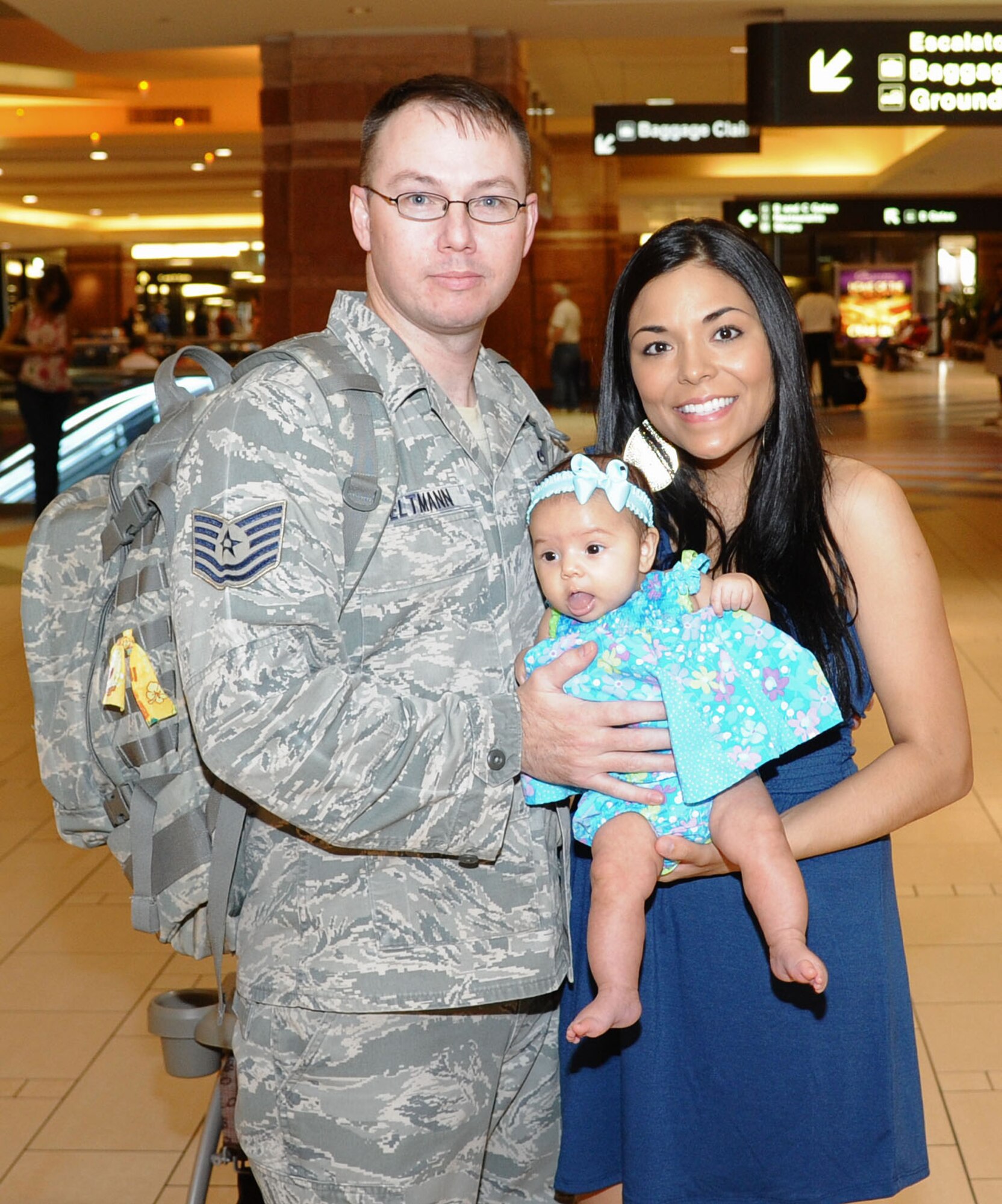 Tech. Sgt. Christopher Seltmann, 56th Fighter Wing weapons safety, and Staff Sgt. Darlene Seltmann, 56th Fighter Wing Public Affairs, pose for a photo with their 3-month old daughter, Brooklyn, Aug. 3 at Phoenix Sky Harbor International Airport after he returned from a six-month deployment to Southwest Asia. (U.S. Air Force photo by Senior Airman Sandra Welch) 